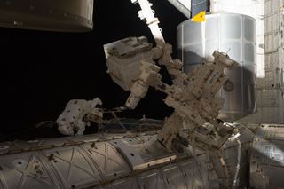 Astronaut Mike Fossum spacewalks outside space station.