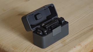 DJI Mic Mini kit inside charging case on a wooden table