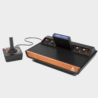 Atari 2600+ console next to controller on grey backdrop