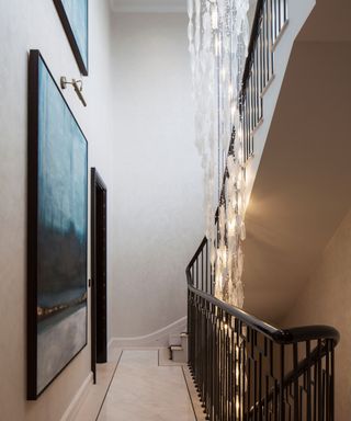 A staircase with a large, hanging light fixture spanning three floors