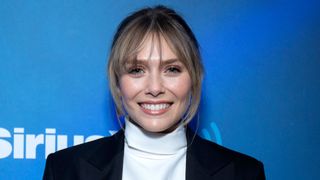 elizabeth olsen on the red carpet head shot with hair in an up do
