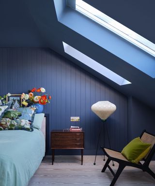 bedroom with sloped ceiling, dark blue color drenched walls and ceiling