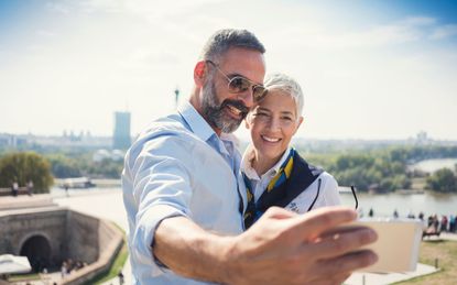 Traveling middle-age couple take a rooftop selfie