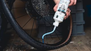 Squirting tubeless sealant into tire using the valve