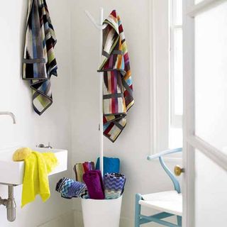 bathroom with white wall and clashing patterned towels