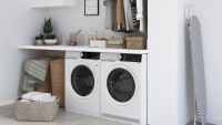 white freestanding washing machine and tumble dryer next to each other under worktop in white utility room
