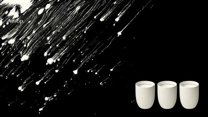 Black background with three white candles on bottom right in a line
