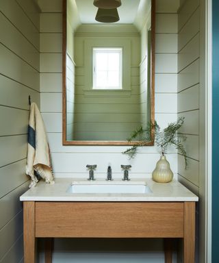 powder room with wooden washstand, mirror and off white cladding