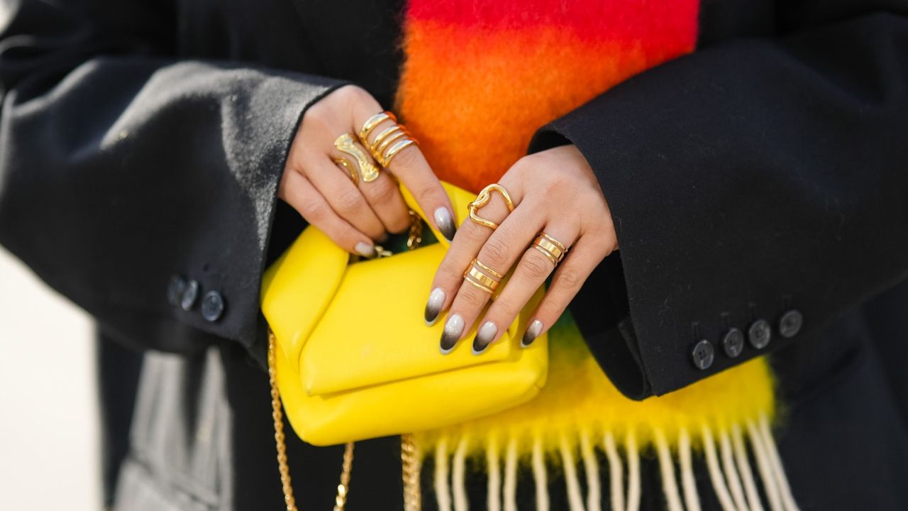 a woman with a russian manicure and a brightly colored bag