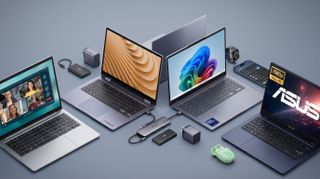 Four laptops with diverse screens are surrounded by gadgets, including a smartwatch, smartphone, and chargers, on a gray surface. The vibe is modern and tech-savvy.