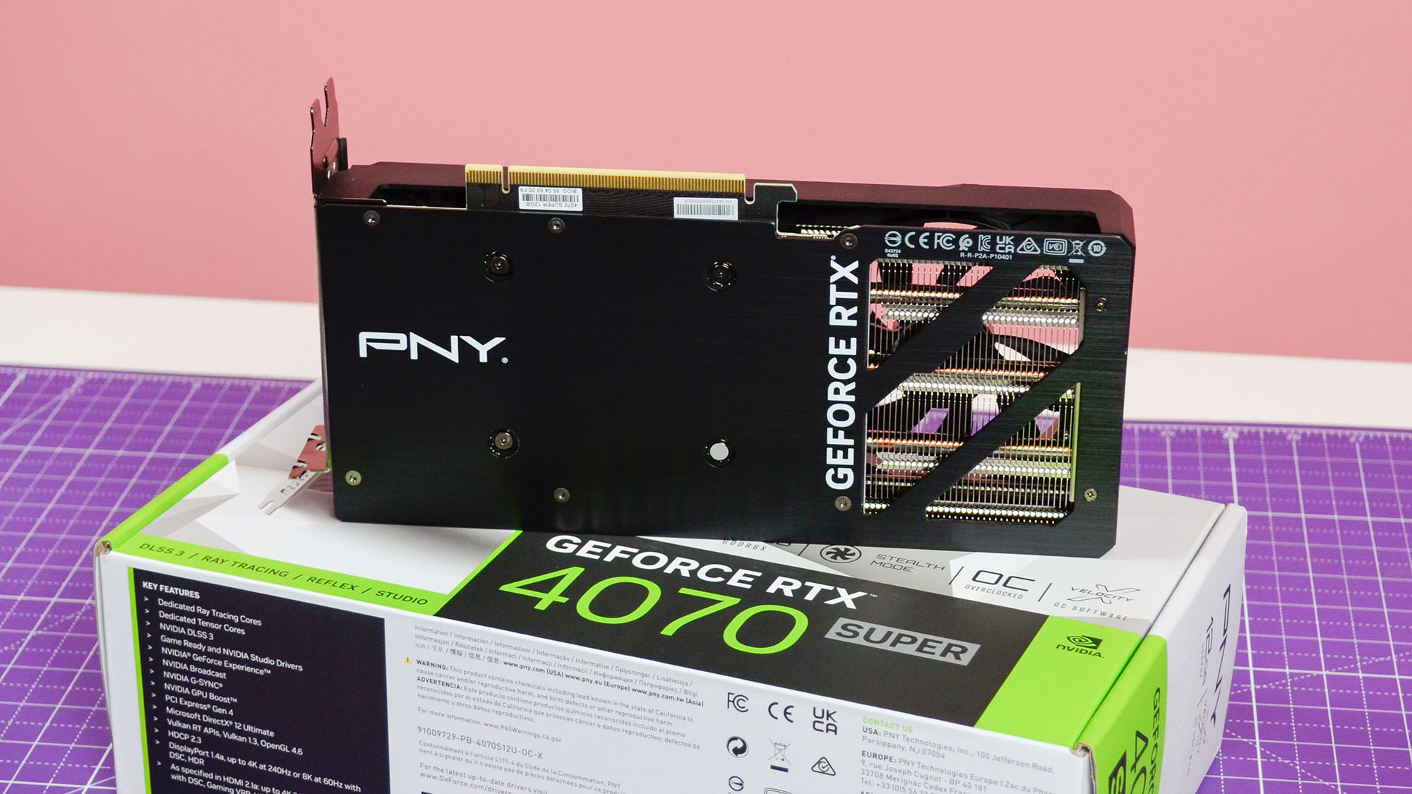 A PNY GeForce RTX 4070 Super Verto OC graphics card on a table with its retail packaging