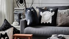 ikea halloween sofa with a black cat and a ghost pillow