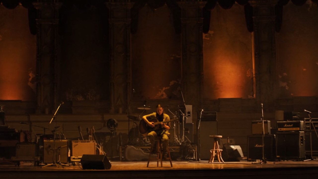 Bella Ramsey as Ellie playing guitar in The Last of Us.