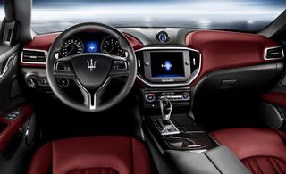 Image taken from the driving sear of a Maserati showing the steering wheel and dashboard