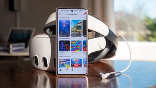 The Meta Horizon app on an Honor Magic V5 smartphone in front of a Meta Quest 3 VR headset