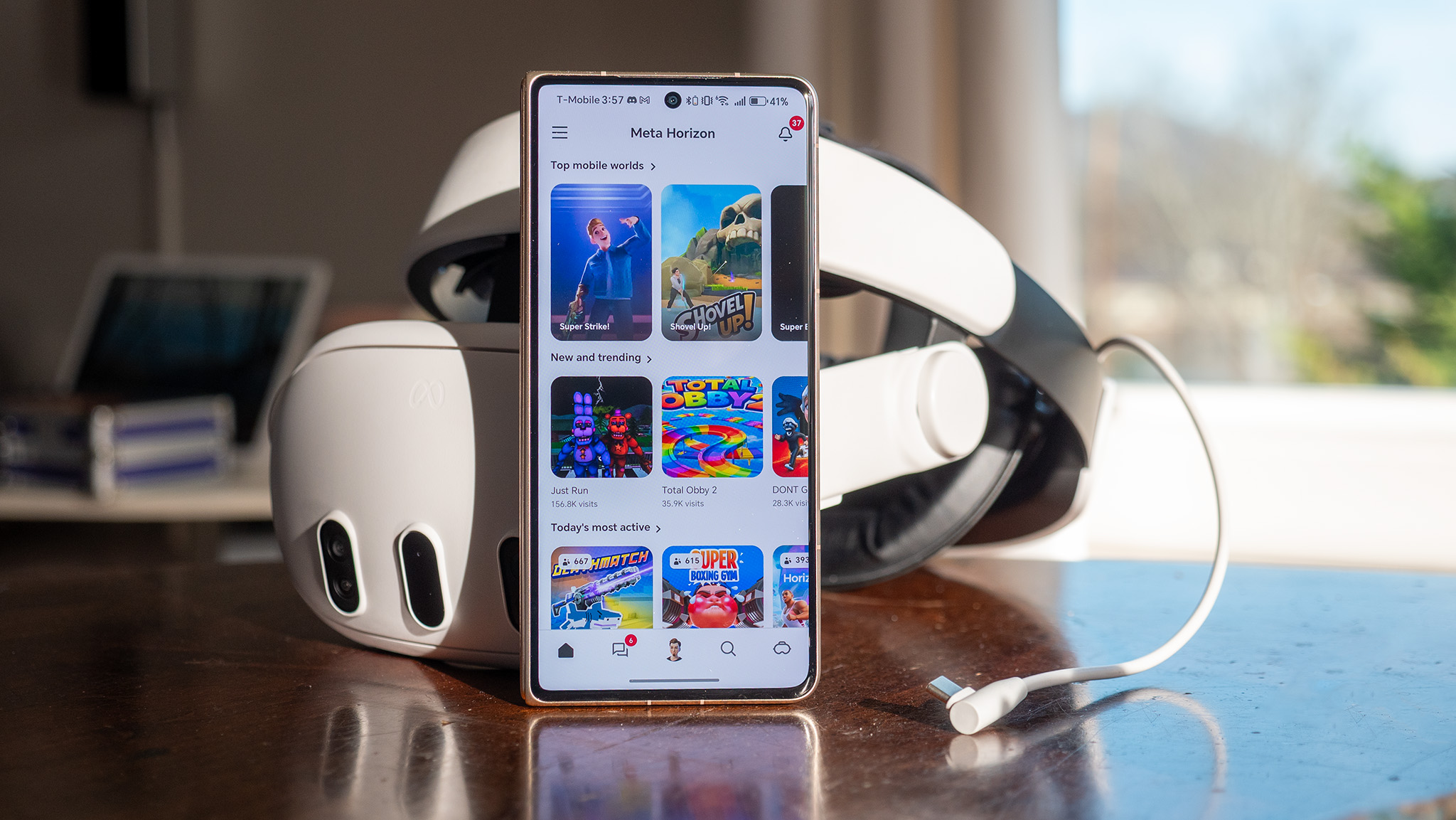 The Meta Horizon app on an Honor Magic V5 smartphone in front of a Meta Quest 3 VR headset