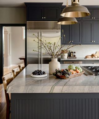 kitchen renovation rules, dark grey kitchen with chrome built in refrigerator, brass pendants, kitchen island with thick marble countertop