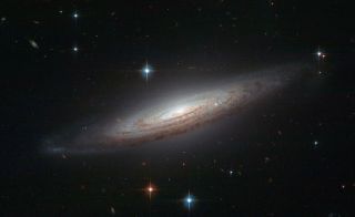Spiral galaxy NGC 634 appears to have a perfect spiral structure, as shown by this Hubble Space Telescope photograph. However, recently a type Ia supernova known as SN2008a was spotted in the galaxy, and it briefly rivalled the brilliance of its entire ho