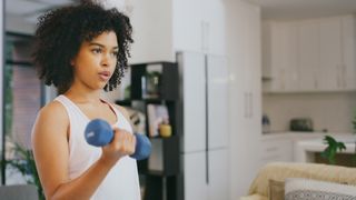 Woman doing bicep curls with a hand weight at home