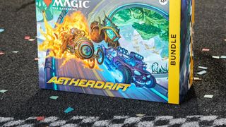 MTG Aetherdrift Bundle box on a tarmac surface, in from of a checkered start line