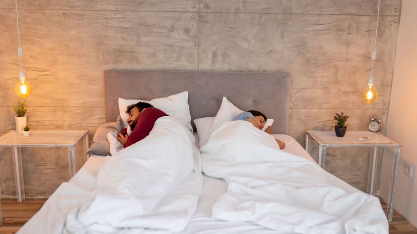 A couple sleeping in bed using the Scandinavian Sleep Method of separate white duvets.
