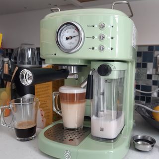 A green Swan Retro One Touch Espresso Machine making a cappuccino