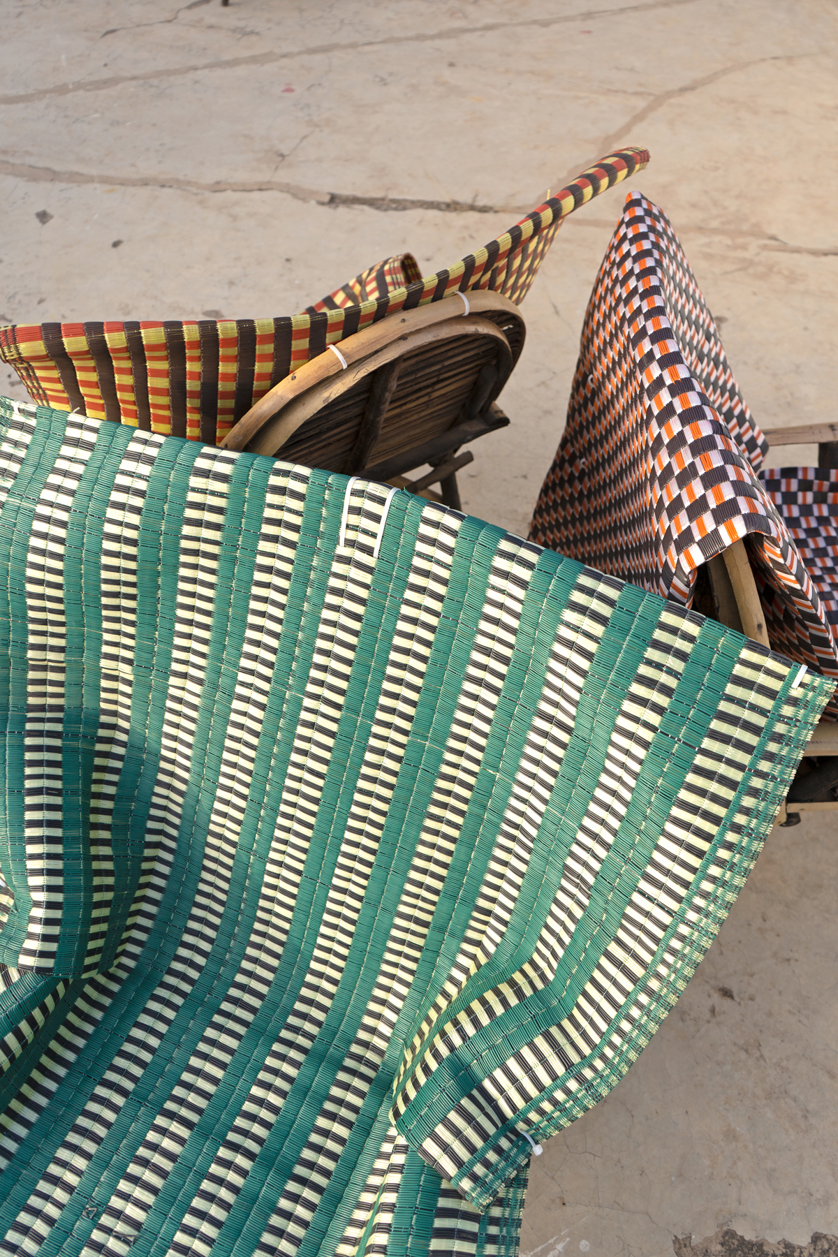 colourful woven mats folded over bamboo chairs