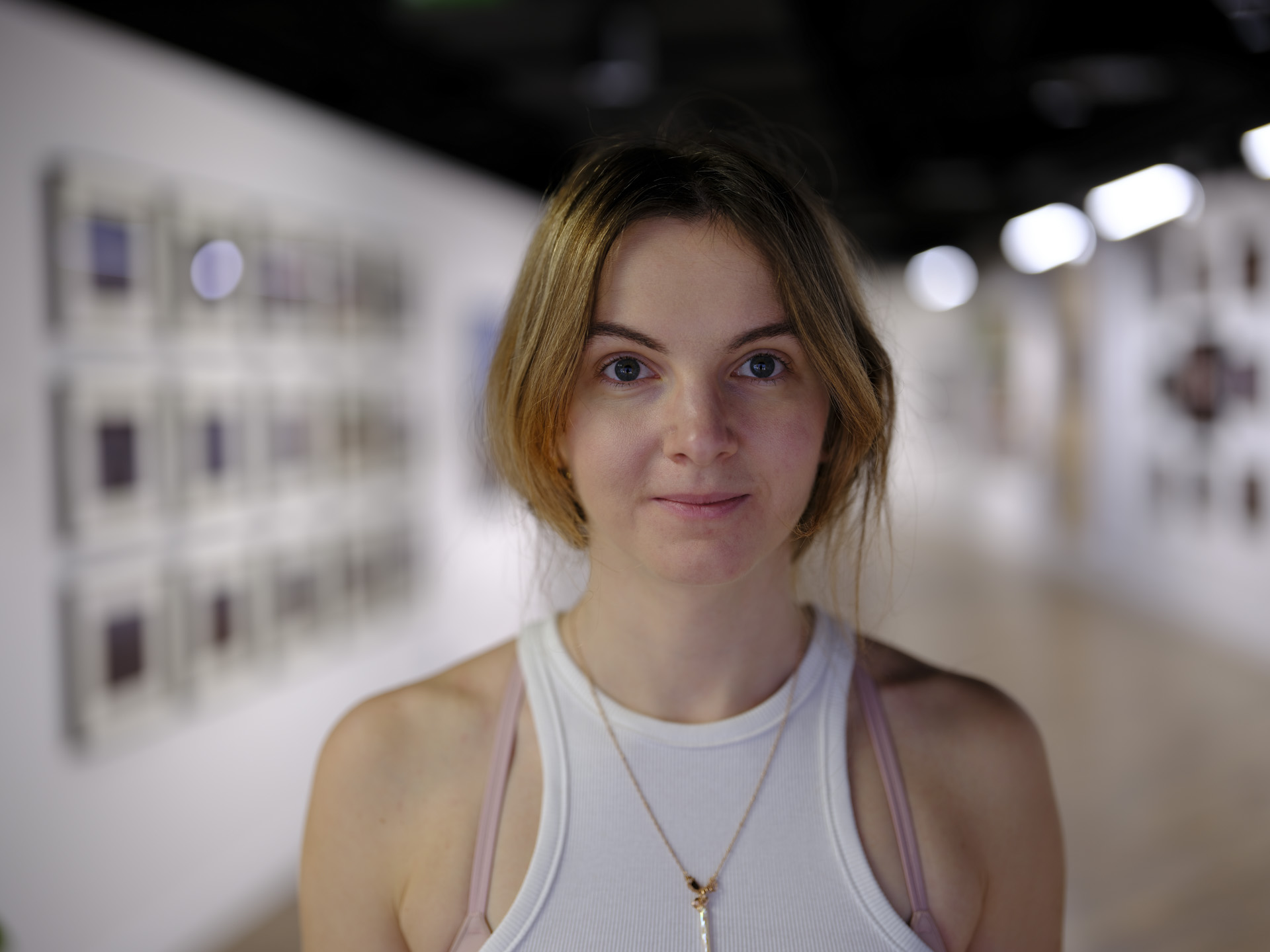 Portrait of a lady in an art gallery, photo using the Fujifilm GFX100 II and GF 55mm F1.7 lens
