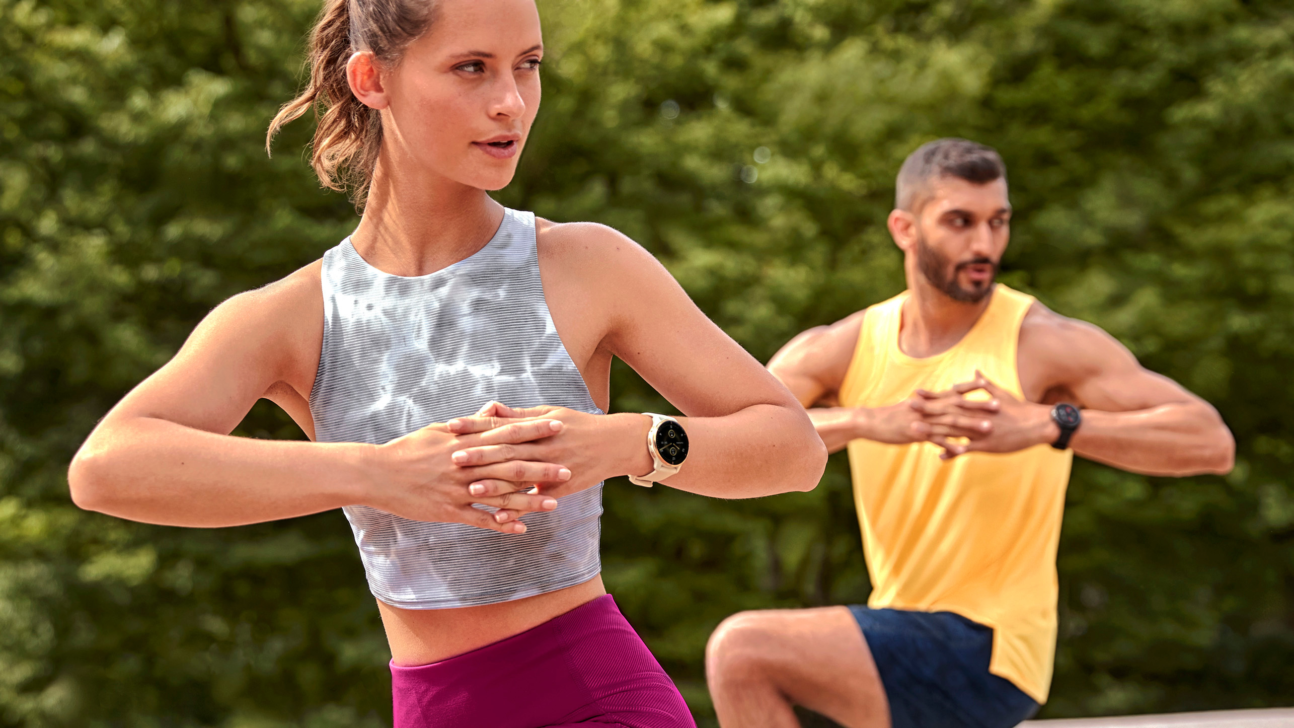 Man and woman working out wearing Garmin Venu 2 Plus watches