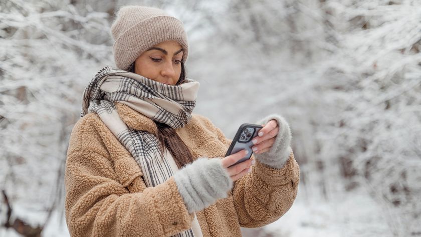 Beautiful Brunette Woman using phone in the winter forest