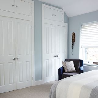 bedroom with white window and two fitted white wardrobe
