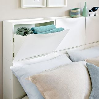 pillows on bed with white storage units behind