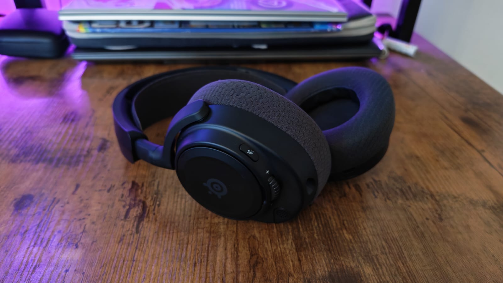 A black SteelSeries Arctis Nova 7 Gen 2 lying on a gaming desk