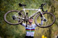 Fem van Empel lifts her bike above her head after the Koppenbergcross