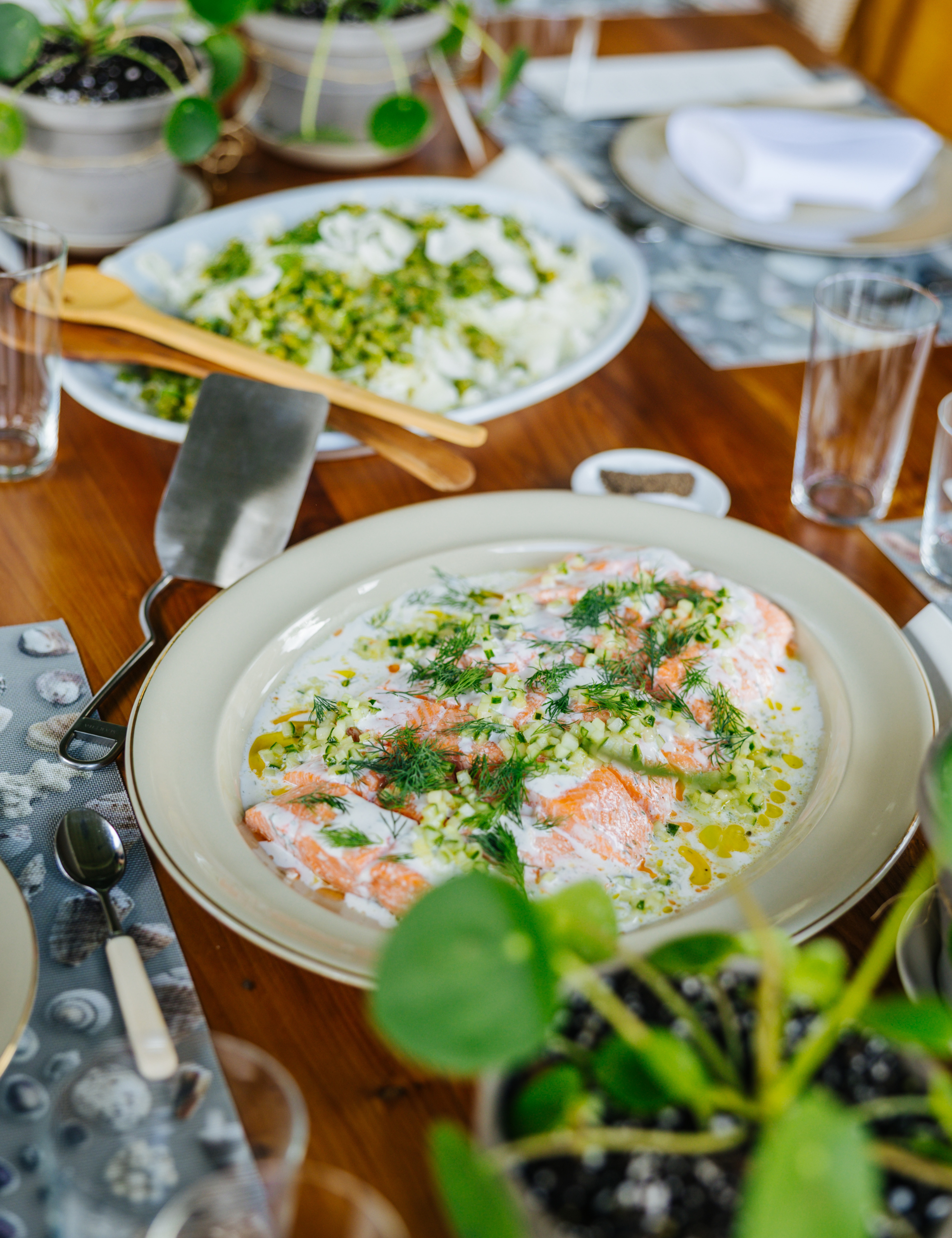 Outdoor summer tablescape featuring neutral tableware and a series of money trees