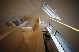 garage conversion with mezzanine sleeping pod lined with plywood