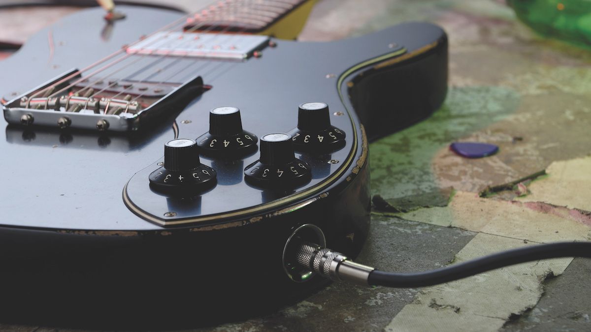 Close up of electric guitar jack with a cable plugged in