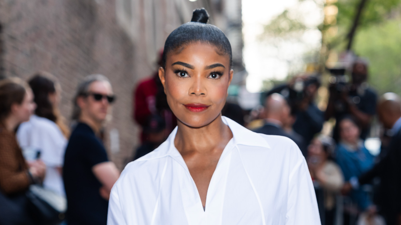 Gabrielle Union wearing red lipstick, a high ponytail, and a white shirt