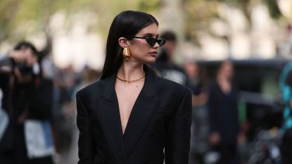 ghd black friday - model wearing sunglasses with straight hair looks over her left shoulder - gettyimages 1718327740