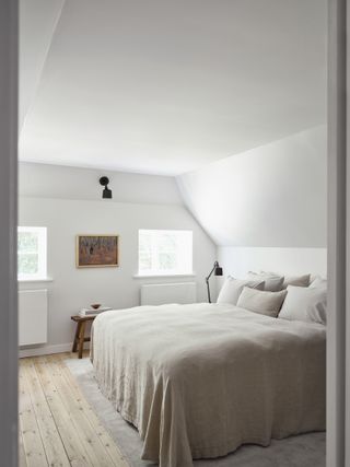 A bedroom with minimal colour palette of white and beige