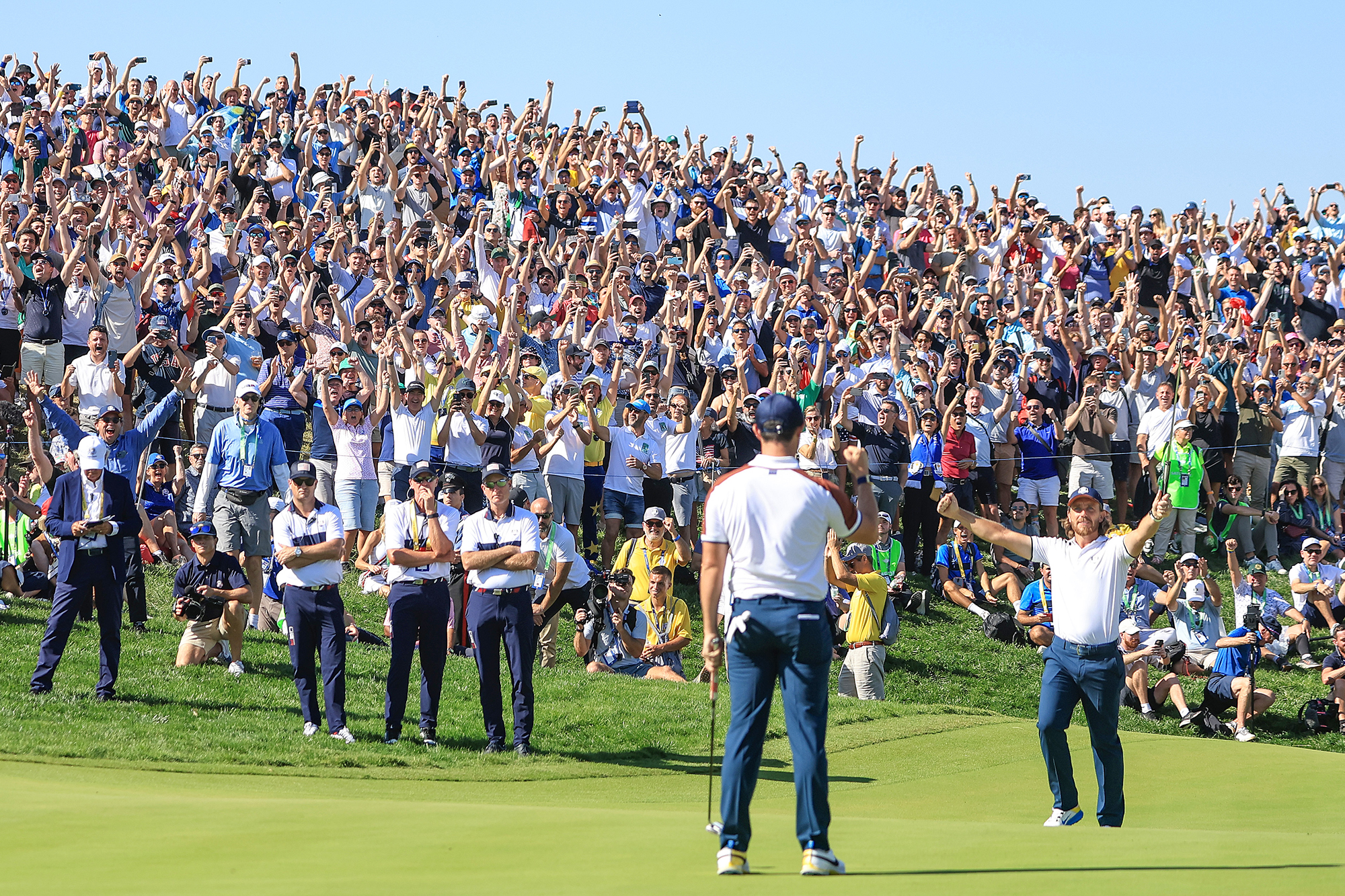 Tommy Fleetwood celebrating in front of foursomes partner Rory McIlroy after he holed a putt at the 2023 Ryder Cup in Rome