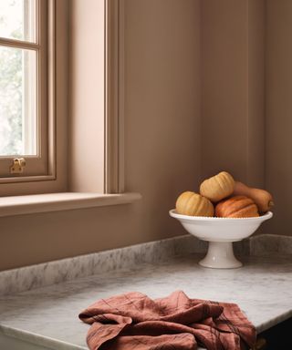 Light brown walls and window, white marble countertop