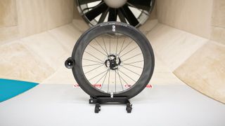 A front Enve Foundation 65 wheel sits in front of the fan within a wind tunnel