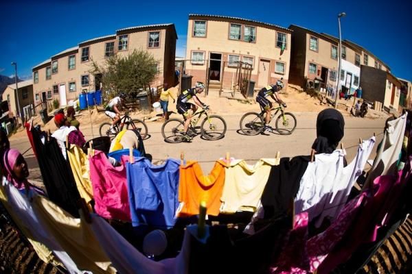 Daily life goes on as racers roll past.