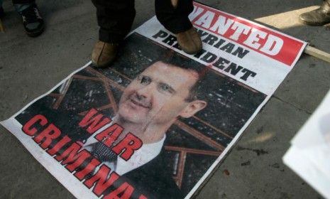 A protester steps on a poster of Syrian President Bashar al-Assad during demonstrations in London: World leaders are concerned Assad will tap into the country&amp;#039;s stockpile of chemical weapons 