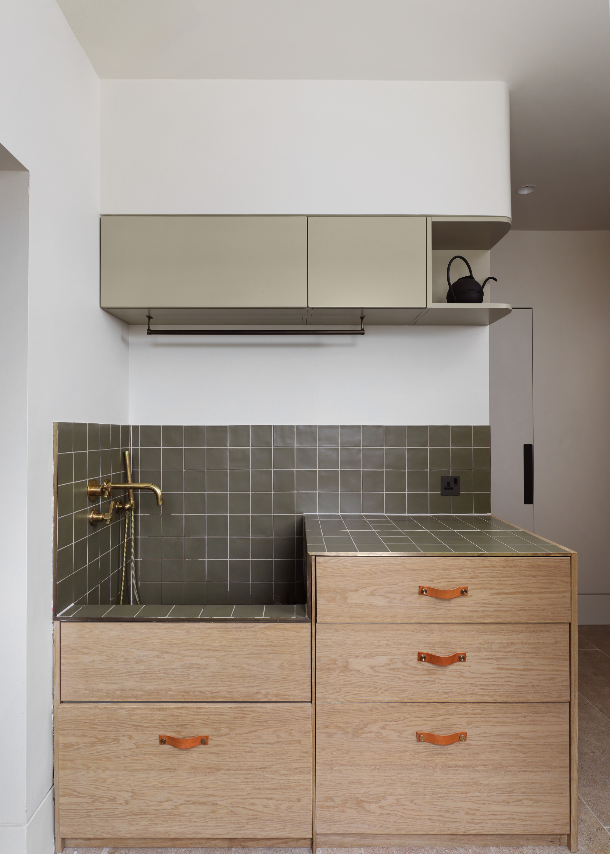 dog bath with green tiles and light oak drawers