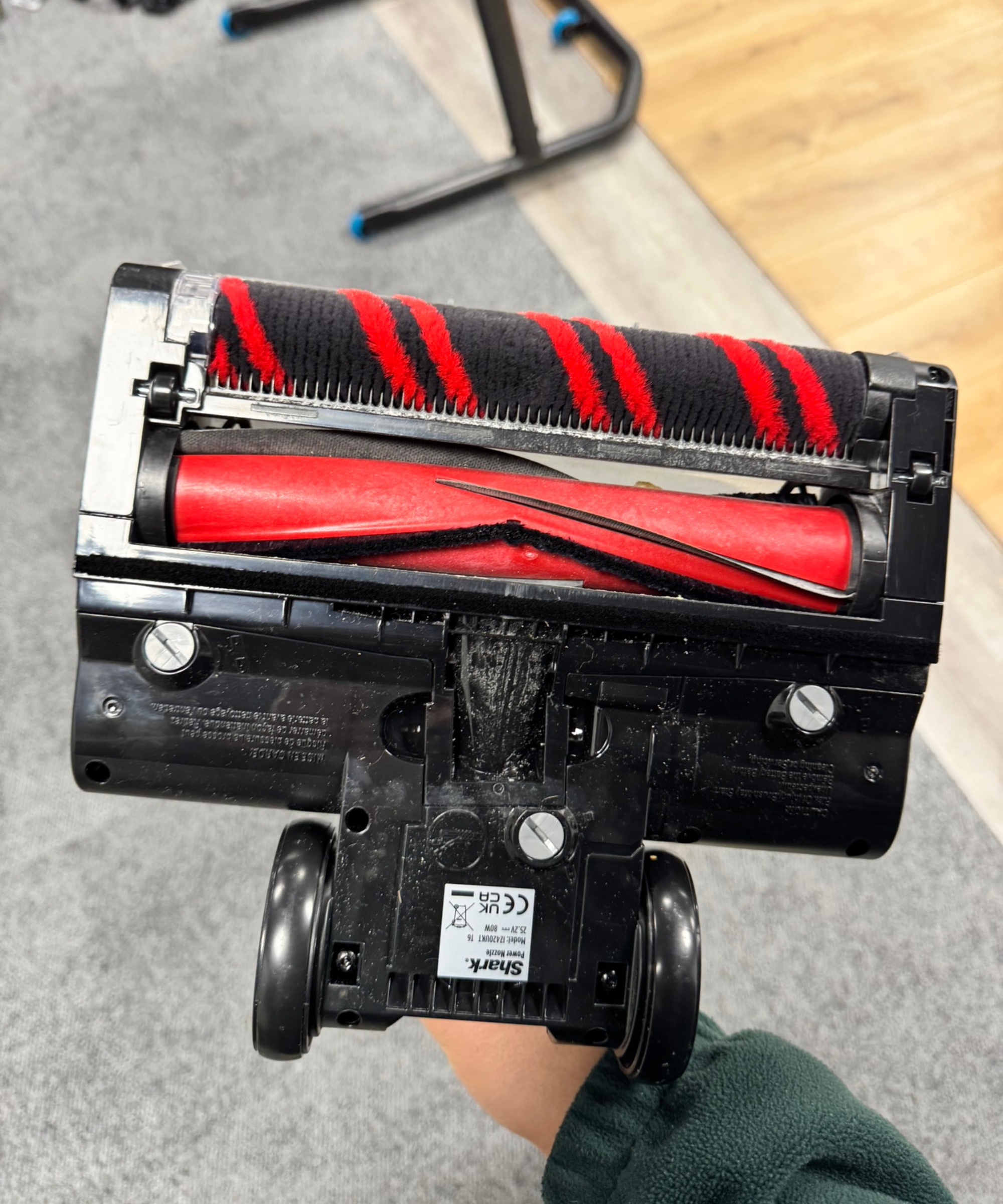 Closeup of underneath the Shark Stratos Cordless Vacuum floorhead, revealing two red brushrolls and black rubber wheels.