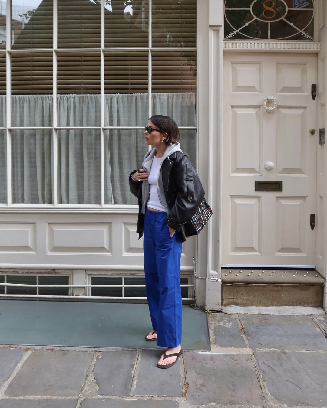 Woman in cobalt blue pants and a leather jacket