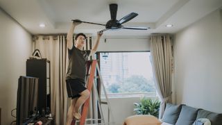 Man cleaning a ceiling fan