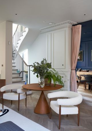 Elegant, white living room with round wooden table